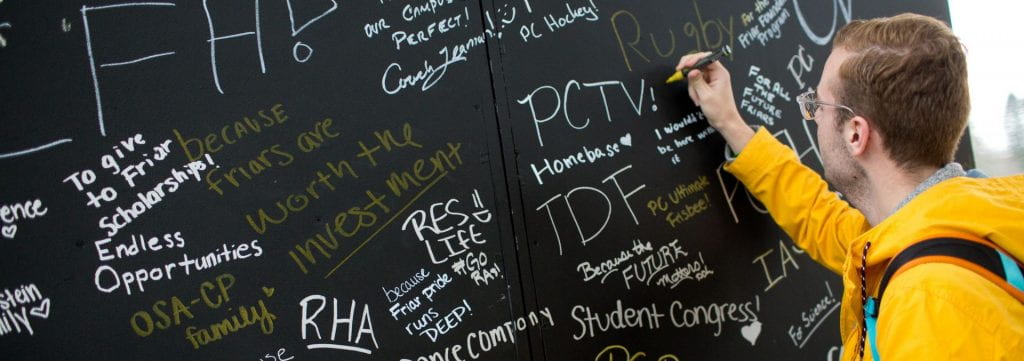 student writing on chalkboard wall, reasons to give to PC